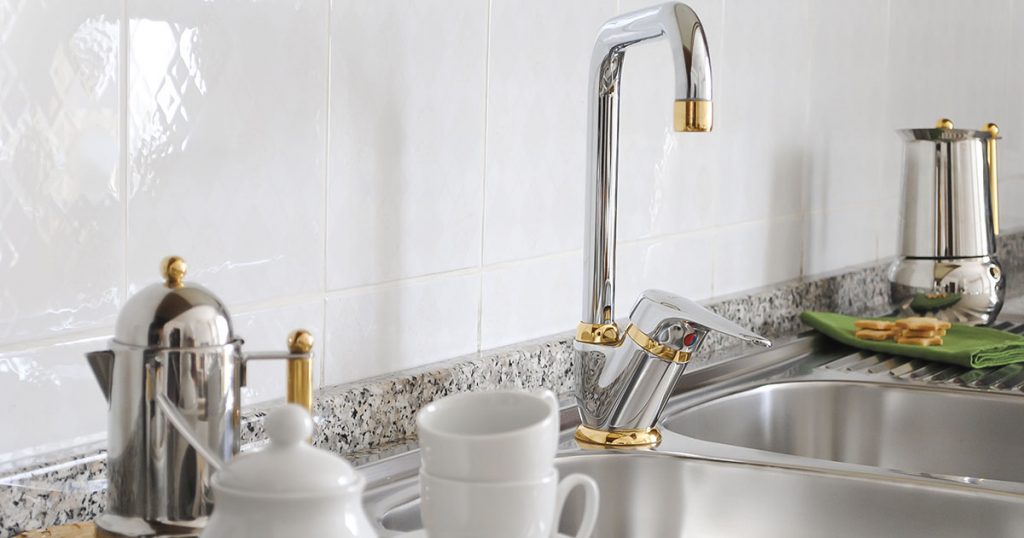 kitchen sink faucet trimmed in gold
