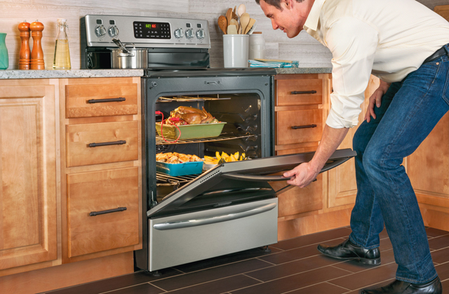 Man opening oven full of food