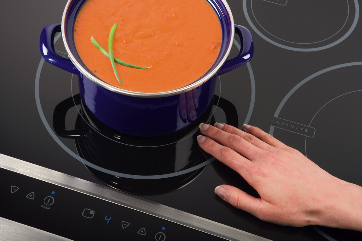 Hand resting near burner of Electrolux induction cooktop