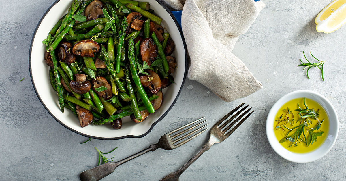 Asparagus and mushrooms sauteed in a cast iron pan